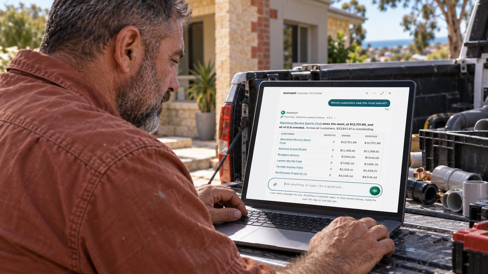 Damien checks the EasyDone Assistant on a laptop at his parked ute outside a plumbing job in Spearwood.
